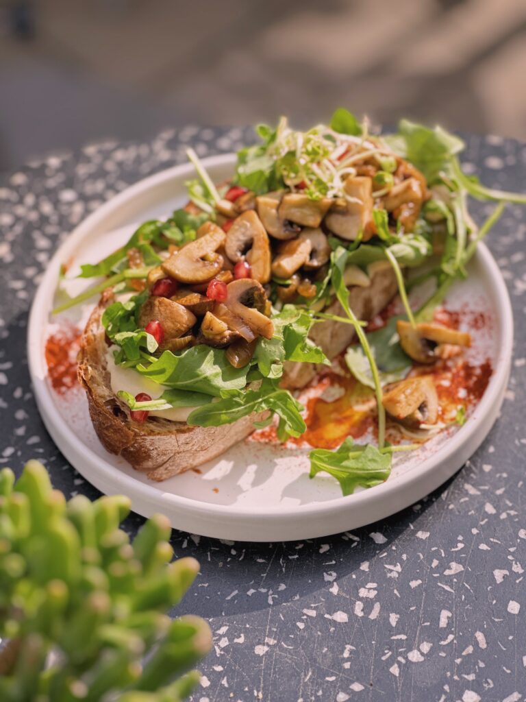 Champignons mit Trüffelöl mit Sauerteigbrot, Frischkäse, Rucola, Champignons, gegrillte Zwiebeln, Trüffelöl & Granatapfel