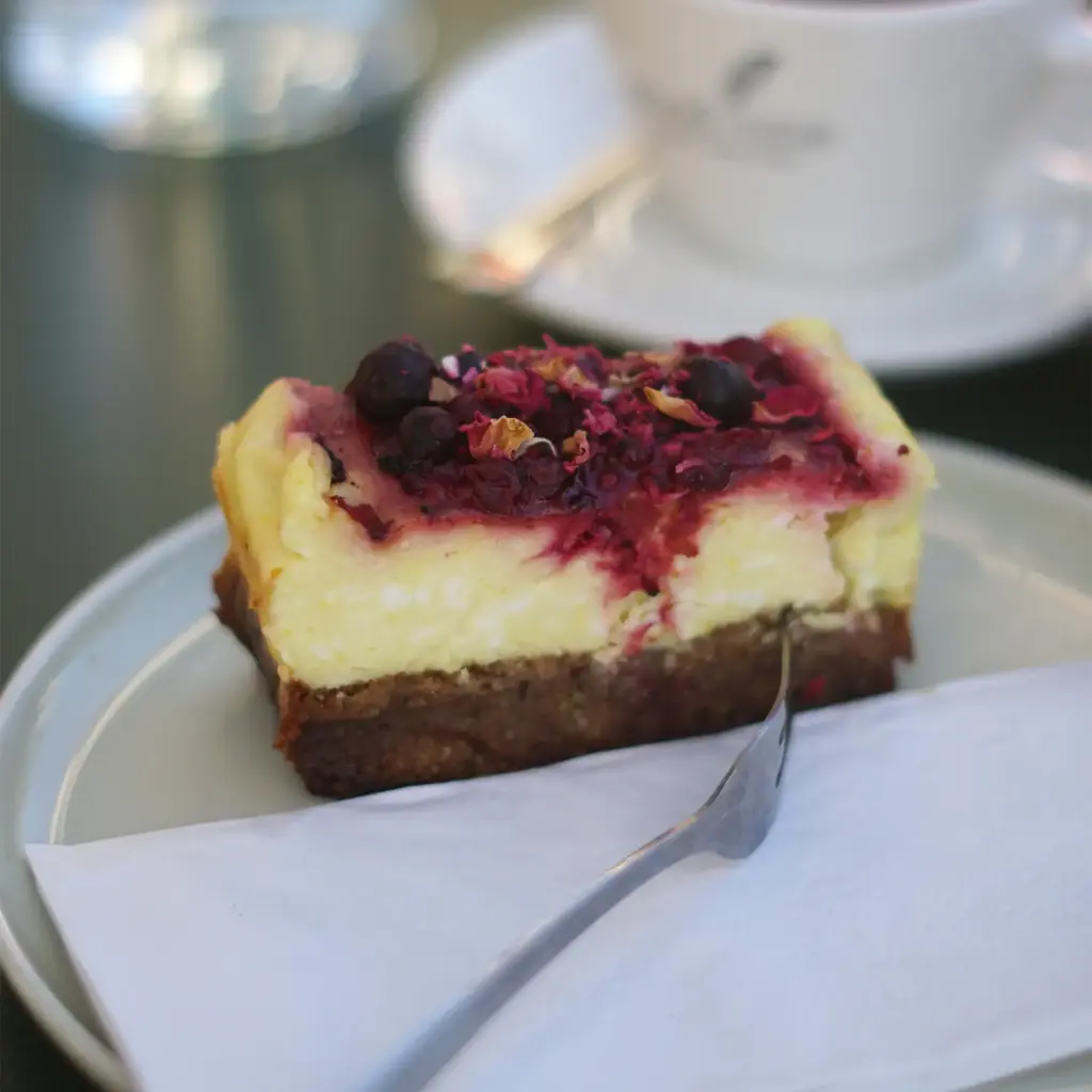 GF Cheesecake mit Cremiger Cheesecake auf glutenfreiem Boden, getoppt mit fruchtiger Beerensauce