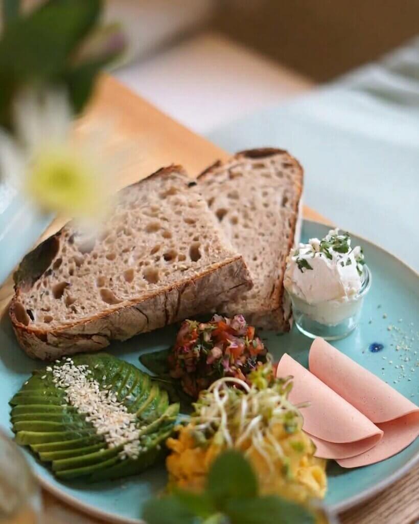 good one breakfast platter mit Sauerteigbrot, „Rührei", „Mortadella", Avocado, "Frischkäse", Spinat